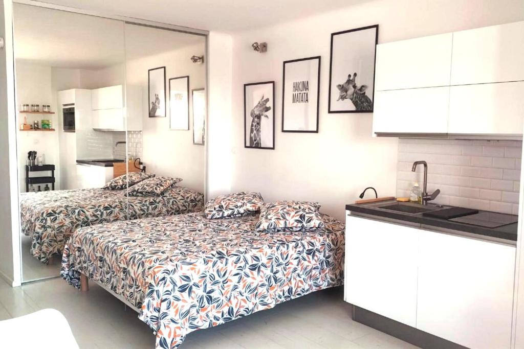 two beds in a small room with a kitchen at 27m with terrace - first row sea view in Six-Fours-les-Plages