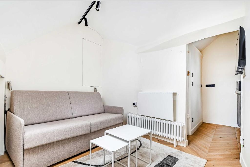 a living room with a couch and a table at Charming Studio 2P - Marais in Paris