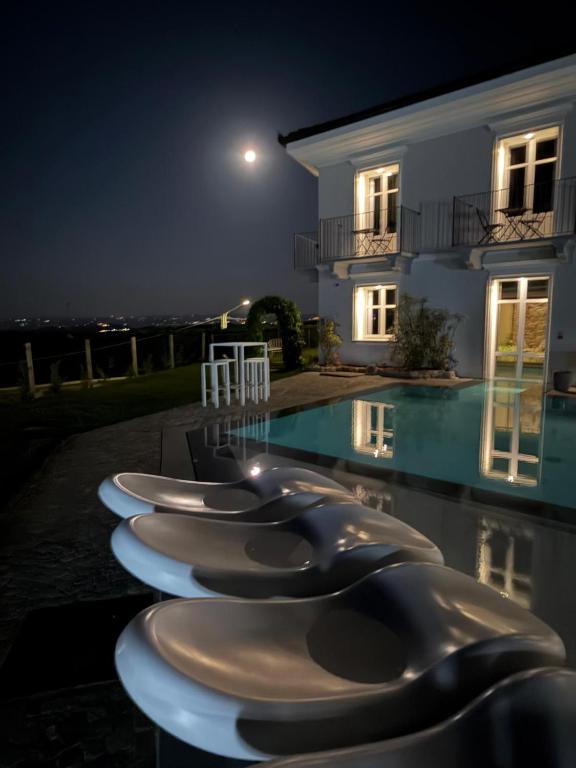 a row of plates lined up next to a swimming pool at night at Villa Regina in Cisterna dʼAsti