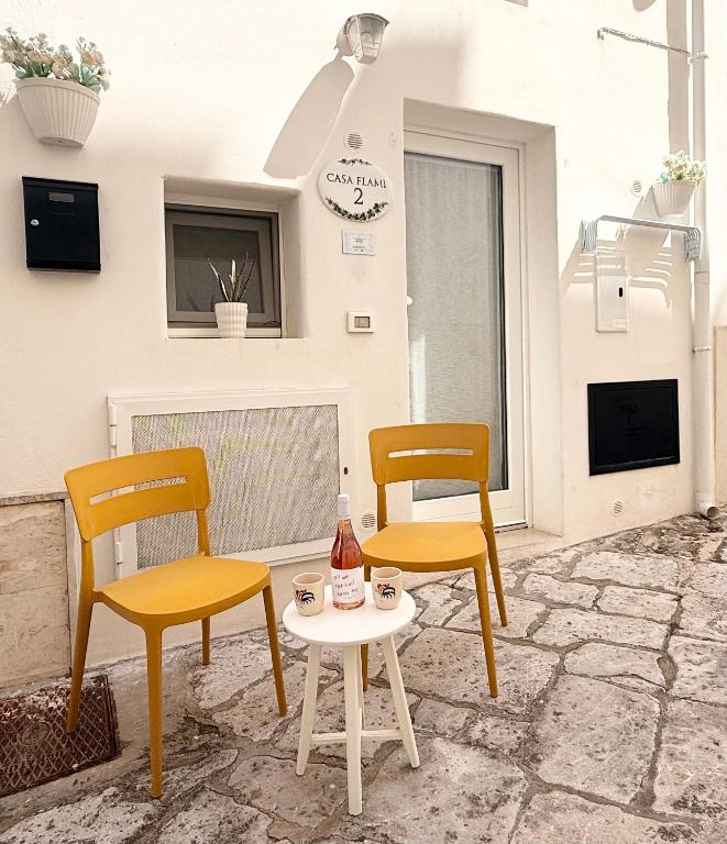 two chairs and a table with a drink on a patio at CASA FLAMÌ 2 in Ostuni