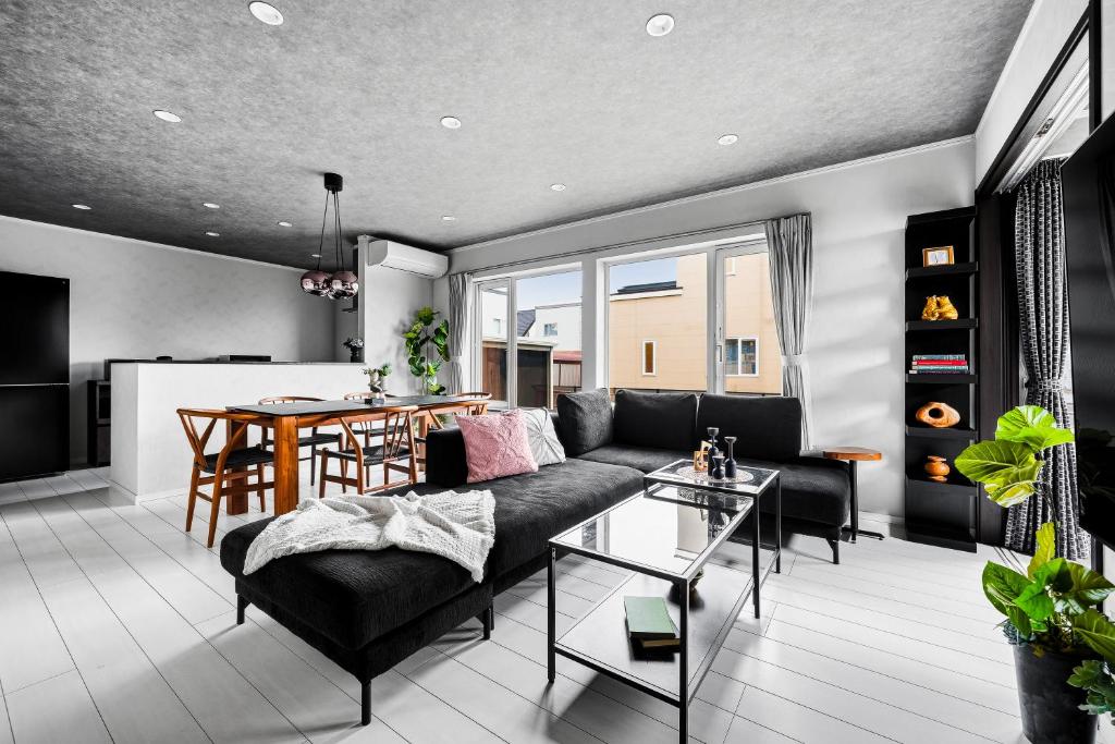 a living room with a couch and a table at The Shelbourne Furano in Furano