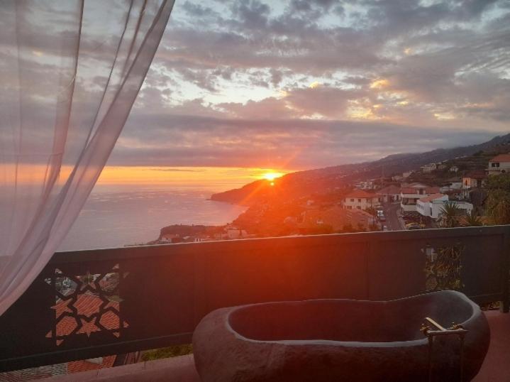 a view of the sunset from a balcony with a couch at Al Dazk in Ribeira Brava