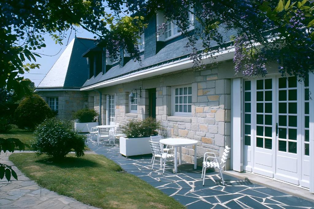 a patio with chairs and a table in front of a building at Au coeur du golfe in Sarzeau