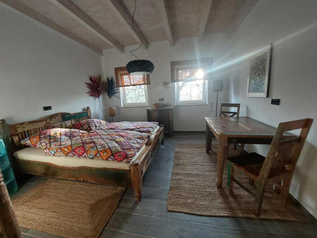 a bedroom with a bed and a table in it at Little-Lama-Lodge in Naila
