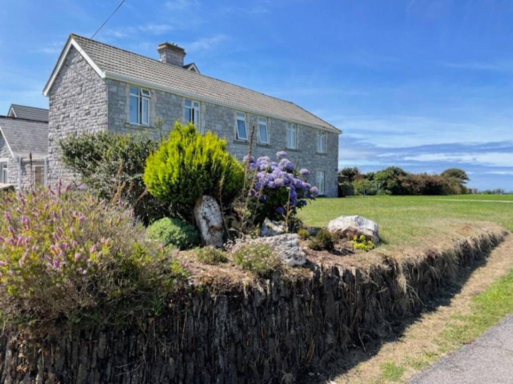 a house with a garden in front of it at 10 The Downs, Thurlestone overlooking Burgh Island in Kingsbridge