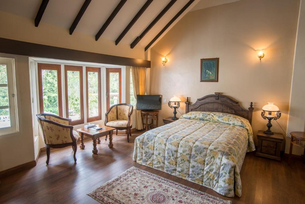 - une chambre avec un lit, une table et des chaises dans l'établissement The Bala's Holiday Chalet, à Cameron Highlands