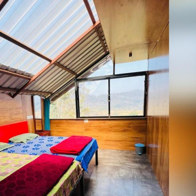 a bedroom with a bed in a room with windows at Apm resort kodai in Kodaikānāl