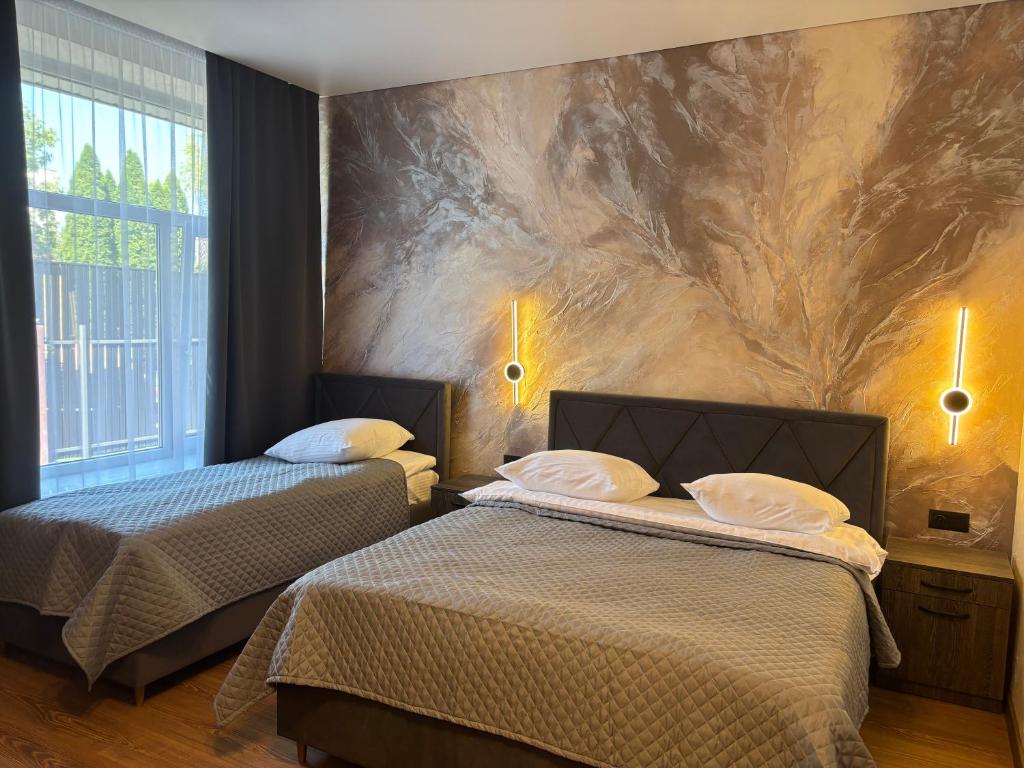 two beds in a room with a wall mural at Safari-Club in Vinnytsya