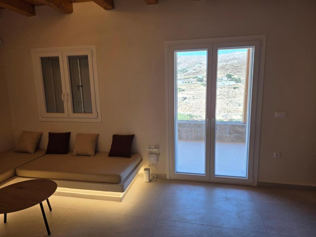 a room with a bed and a large window at Apsila Suites Mykonos in Mikonos