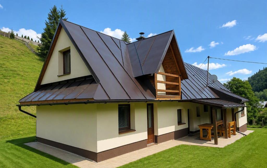 an image of a house with a metal roof at Chata Huta in Muránska Huta
