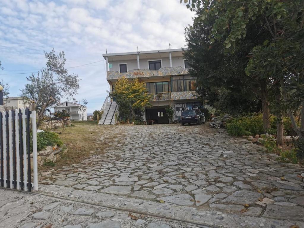 a house with a stone driveway in front of it at Camping BORA in Cërrik