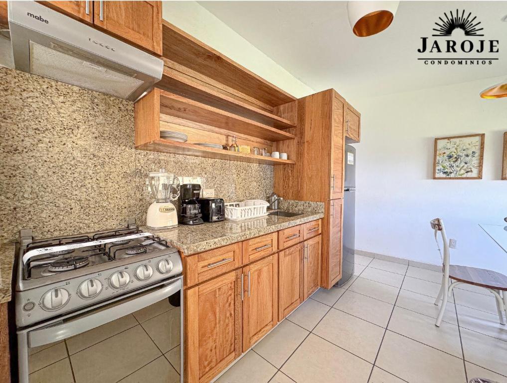 eine Küche mit Holzschränken und einem Herdofen in der Unterkunft Condominios JAROJE Huatulco in Santa Cruz Huatulco