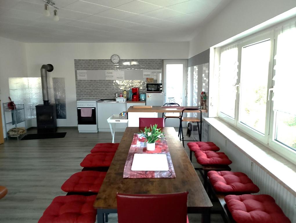 a living room with a table and red chairs at Ferienwohnung Jahnke in Burkardroth
