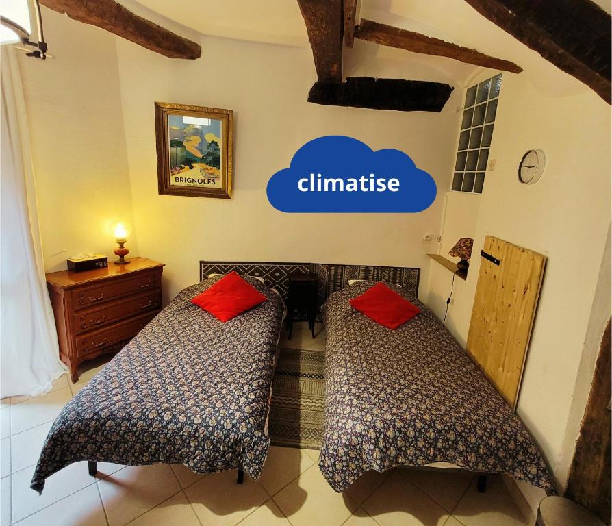 two beds in a room with a clinic sign on the wall at Studio Chez Gregoire w Prowansji in Cabasse