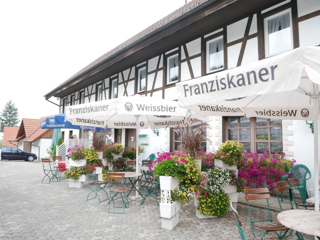 ein Gebäude mit Tischen, Stühlen und Blumen davor in der Unterkunft Seebach-Hotel in Seebach