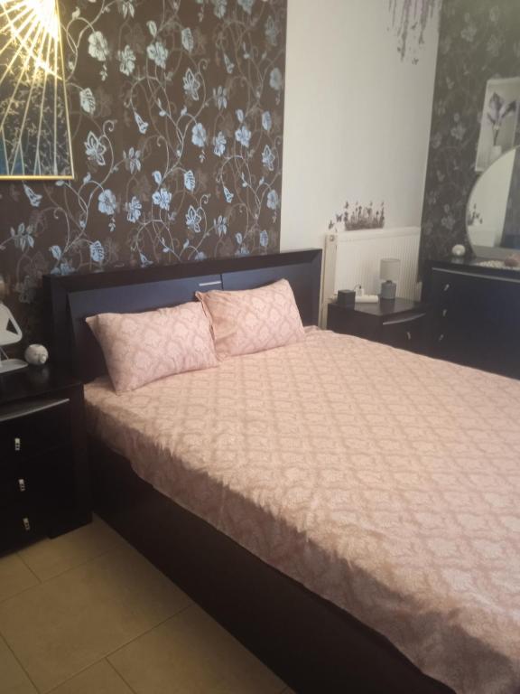 a bedroom with a bed with pink pillows at Lovely suite in Ierissos