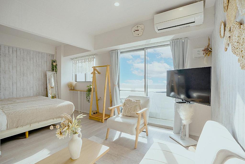 a living room with a bed and a tv in a room at Ocean Front! New Built Apartment! SOU Resort YAKA in Kin