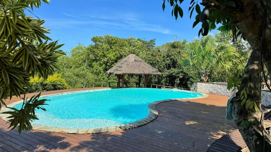 a swimming pool in a resort with a gazebo at La maison du Ruisseau in Saint-Louis
