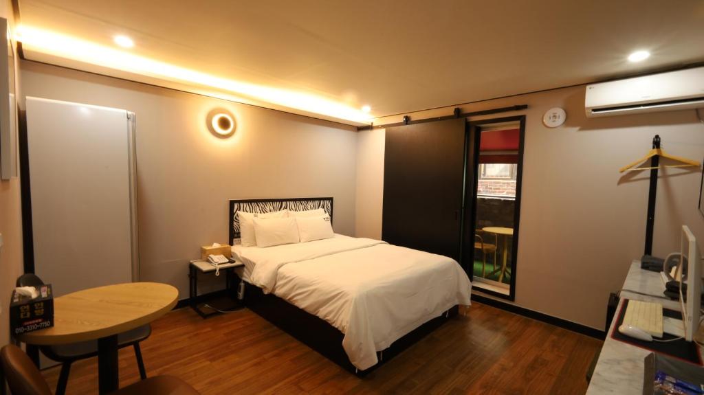 a small bedroom with a bed and a table at 수원행궁 넘버25 in Suwon