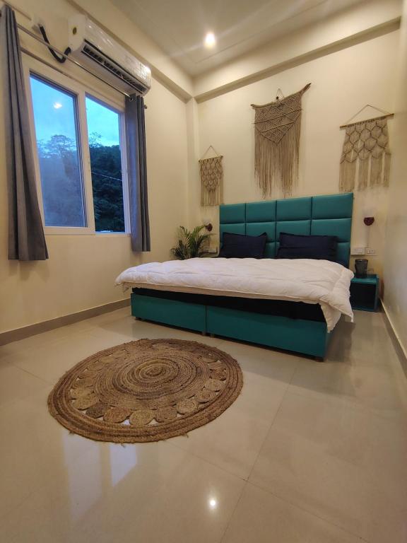 a bedroom with a large bed with a green headboard at Ashirwad Stay in Rishīkesh
