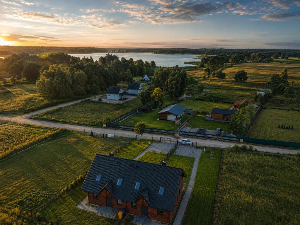 an overhead view of a house in a field with a river at Brajnickie Zacisze in Brajniki