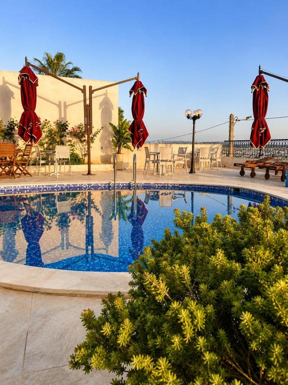 a swimming pool with umbrellas and tables and chairs at Chez Roberto in La Marsa