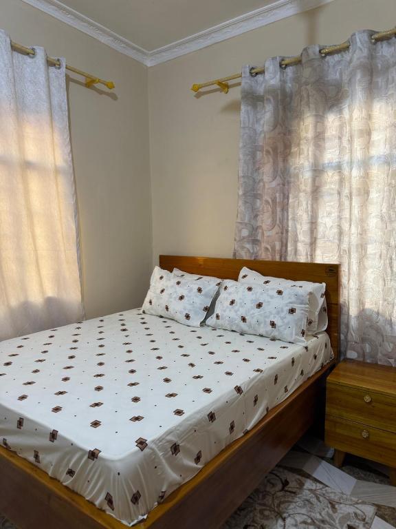 a bedroom with a bed with white sheets and pillows at The Cozy Nest in Tanga