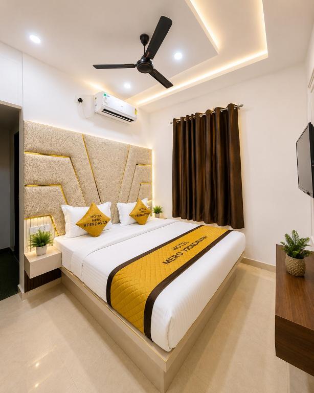 a bedroom with a large bed with yellow pillows at Hotel Mero Vrindavan in Chhatikara