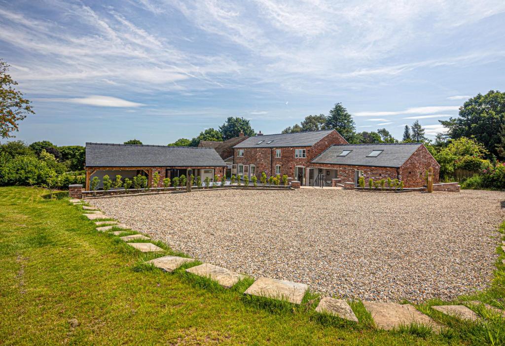 a house with a gravel driveway in front of a building at Fairvale House in Northwich