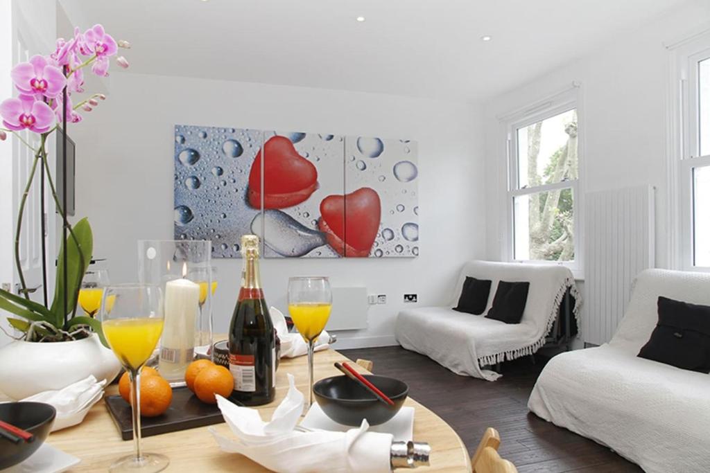 a living room with a table with wine glasses at Holiday Lets London 4 in London