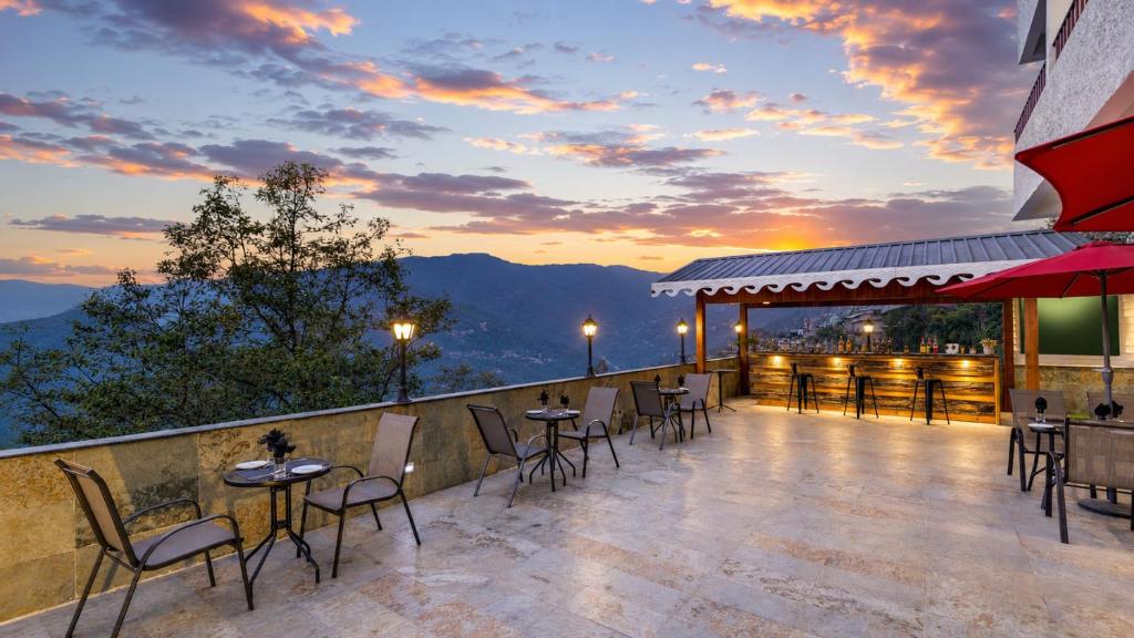 a patio with tables and chairs on top of a building at Mount Himalayan Hotel in Gangtok