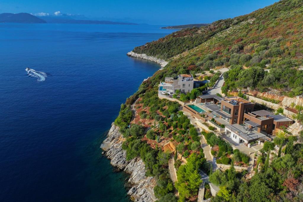 an aerial view of a house on a cliff next to the water at Villa Arkoudaki Luxurious Escape with Infinity Pool & Sea Access in Évyiros
