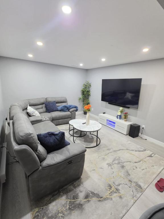 a living room with a couch and a flat screen tv at Cozy New 2BR Suite Retreat in Calgary