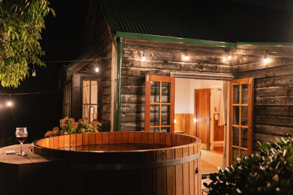 a wooden house with a wine glass and a barrel at Vineyard Cottages - Kumeu in Waimauku