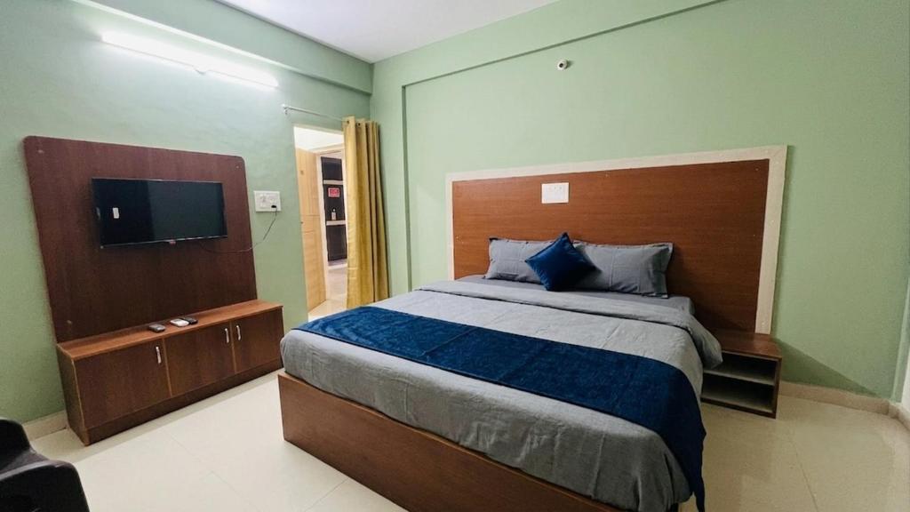 a bedroom with a large bed and a flat screen tv at Fabhotel Aman palace in Mumbai