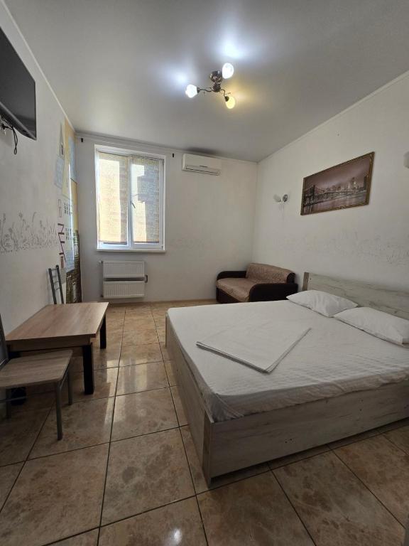 a bedroom with a bed and a table and a desk at ОлександріЯ in Odesa