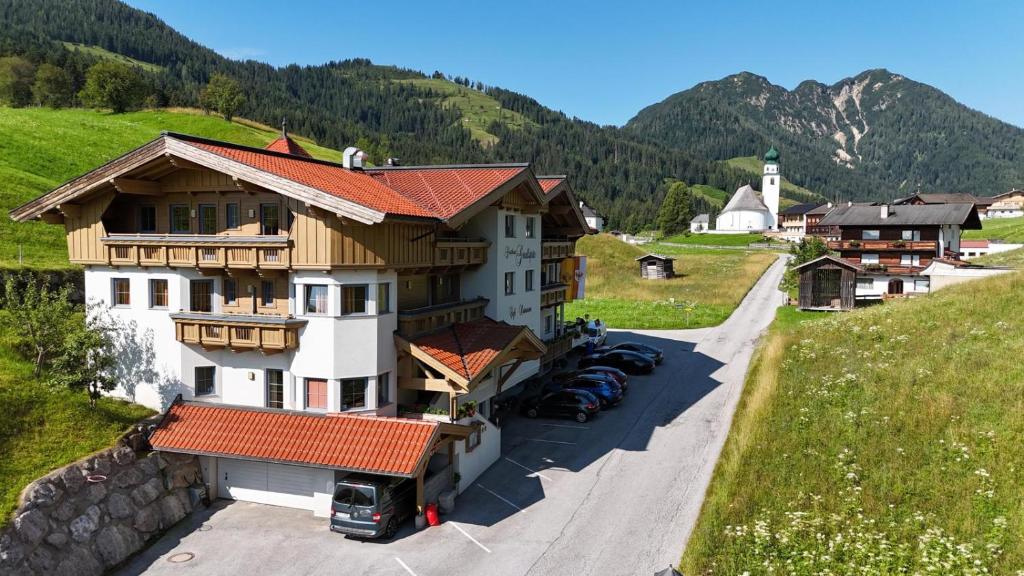 a house on a hill with cars parked in front of it at Gasthof Gradlspitz in Thierbach