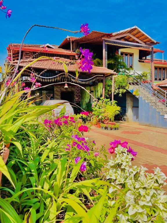 a house with flowers in front of it at Kds Homestay in Gonikoppal