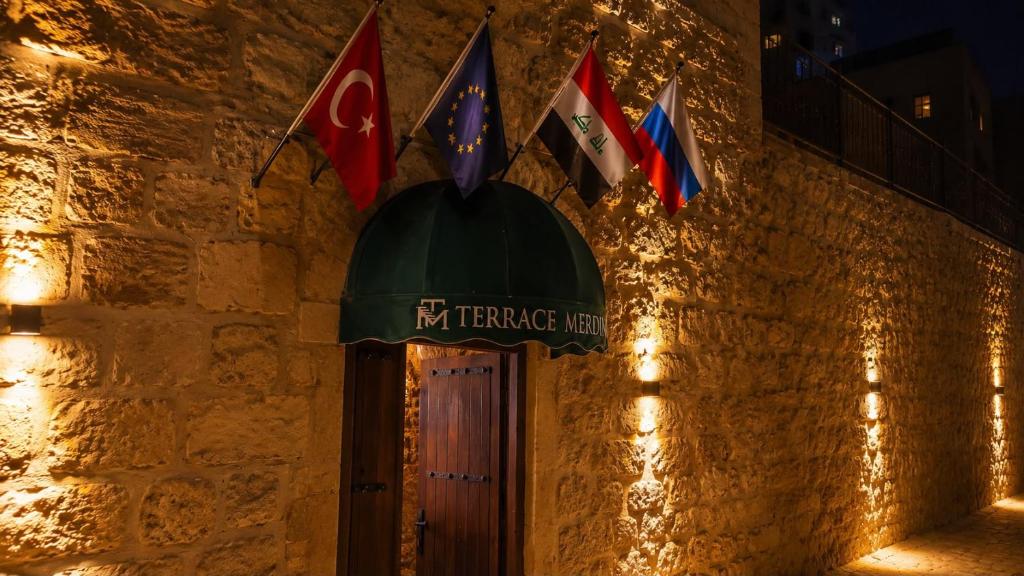 a group of flags on a stone building with a door at Terrace Merdin Konagı in Mardin
