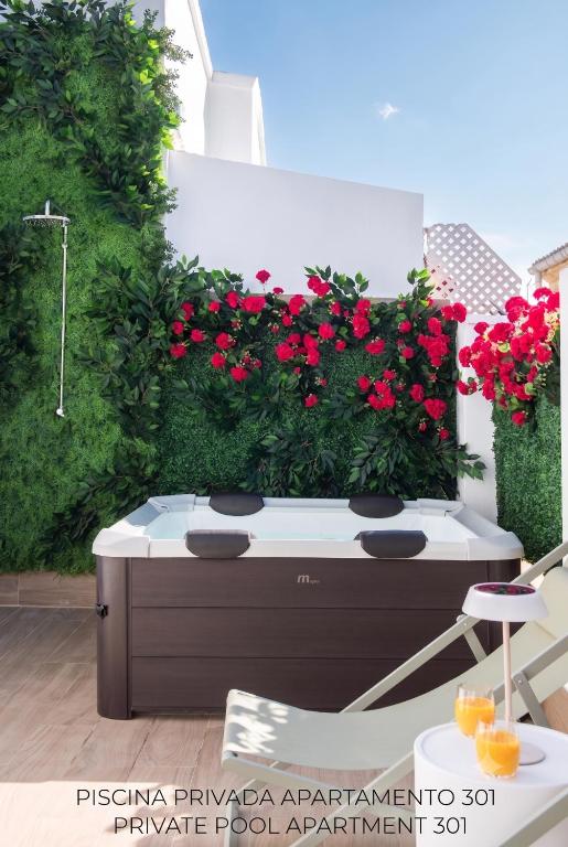 a garden with red geraniums in a room at Casa Carver 1927 by Hommyhome in Seville