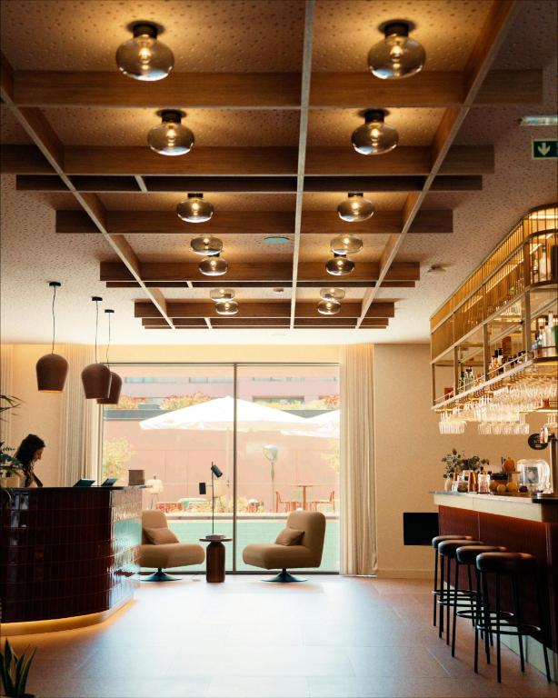 a lobby with chairs and a bar with a view at Hotels 705 O'Porto Hotel in Porto