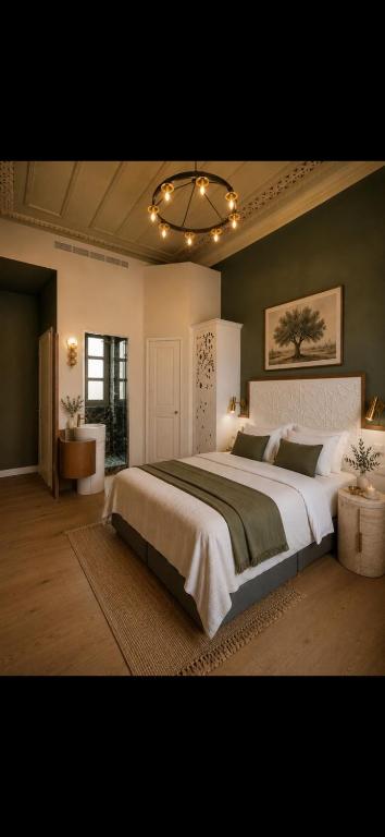 a bedroom with a large bed and a chandelier at Sekeria Hammam & Suites, Historic Mansion Hotel in Heraklio