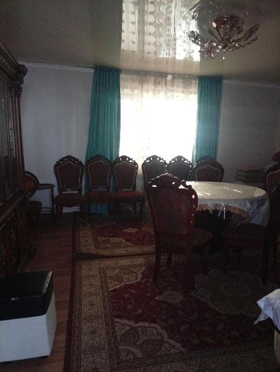 a dining room with a table and chairs and a window at House in the forest in Tyup