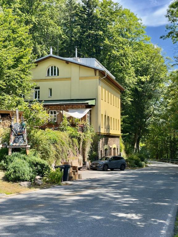 a house with a car parked next to a street at Apartment Vilém in Janske Lazne