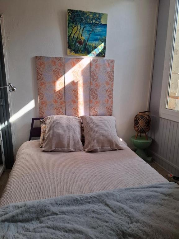 a bedroom with a bed with a cross on the wall at Studio en toute simplicité plein centre in Libourne