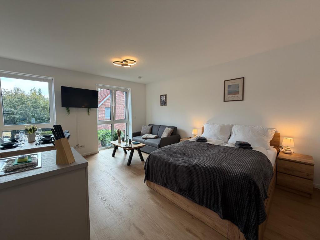 a bedroom with a bed and a living room at Wohnglück Leer City Nr 3 in Leer