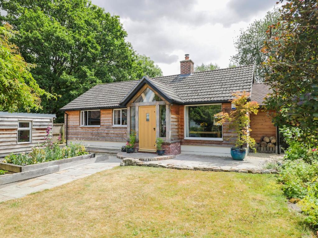 a cottage with a garden and a yellow door at Little Orchard in Swallowcliffe