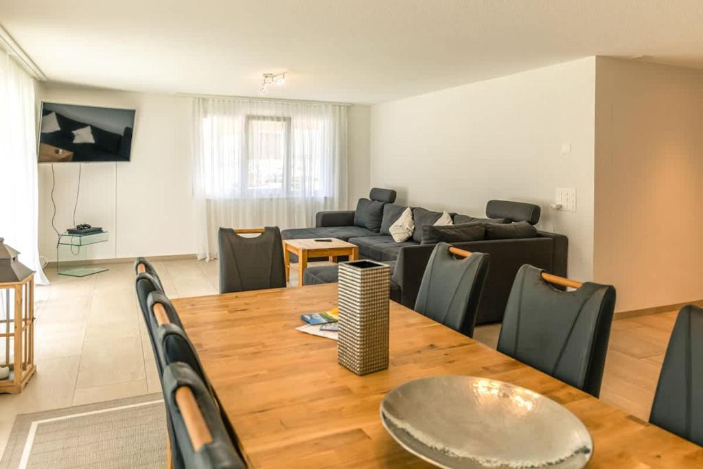 a living room with a table and a couch at Moench Apartment - Aare Jungfrau AG in Wilderswil