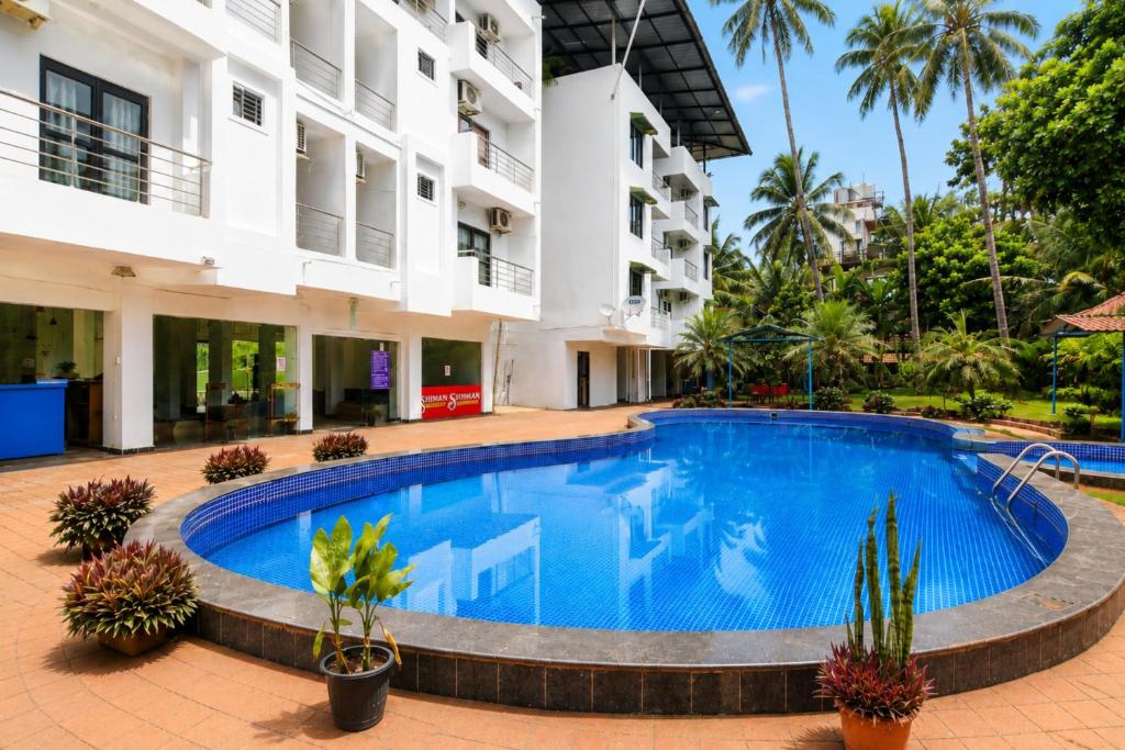 a swimming pool in front of a building at Sunlight Stay at Goa in Calangute