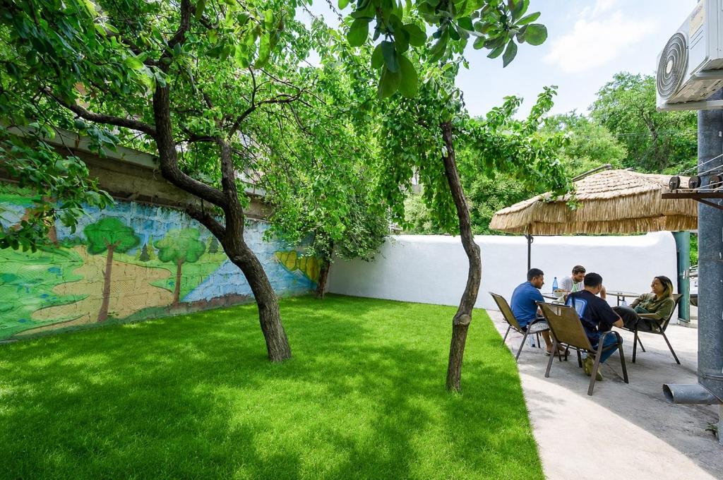 a group of people sitting in chairs in a yard at Garden Hostel 16 in Yerevan